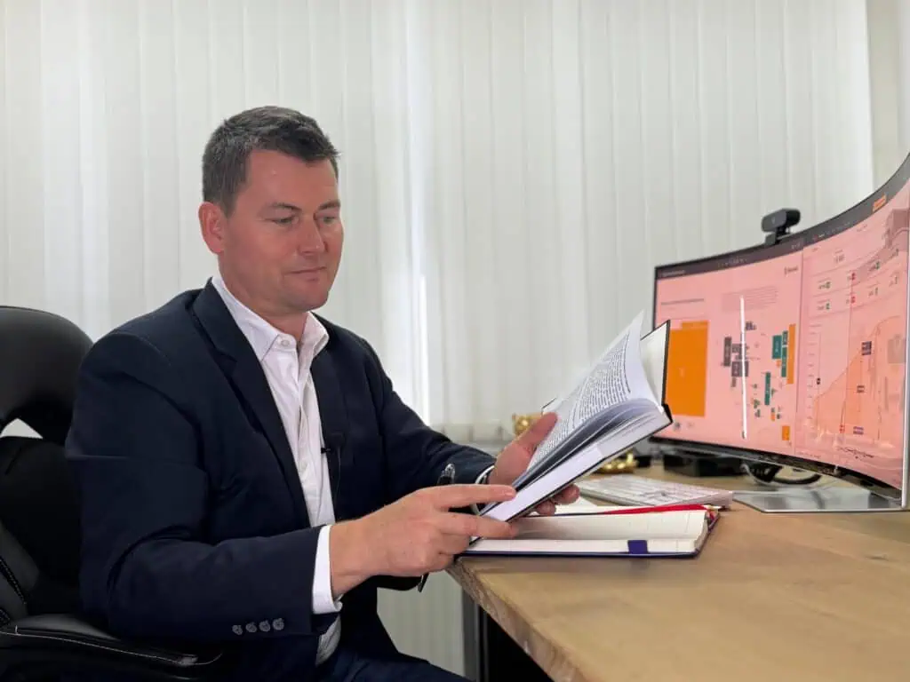 Herbert Tiefenthaler prüft Unterlagen bei der Bestands-Architektur-Analyse am Schreibtisch.